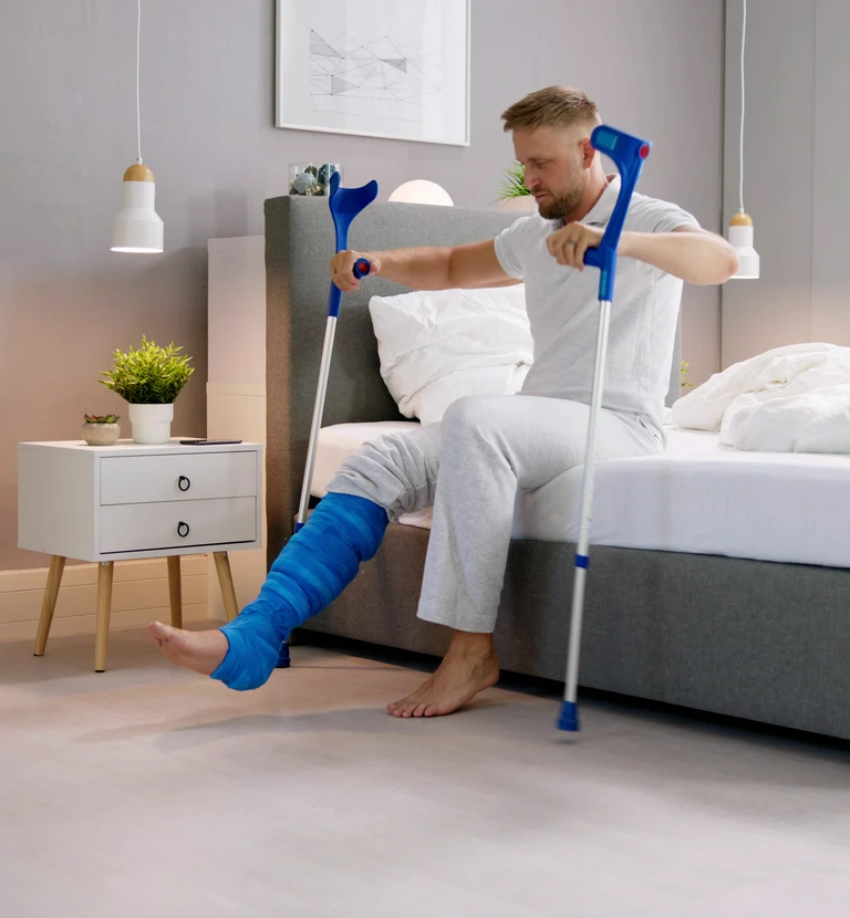 mężczyzna z&nbsp;nogą w&nbsp;gipsie